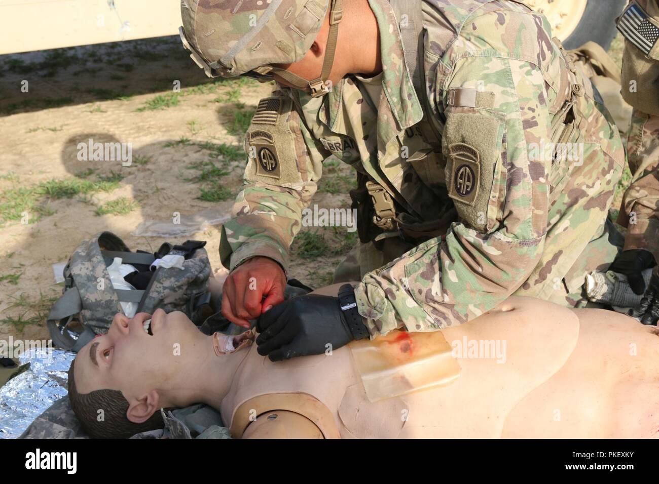 U.S. Army Spc. Danny Brambila, an infantryman with 1st Battalion, 504th Parachute Infantry Regiment, 1st Brigade Combat Team, 82nd Airborne Division, applies a needle decompression on a Tactical Combat Casualty Care Exportable manikin during training on Fort Bragg, North Carolina, July 27, 2018. The TC3X kit was designed to provide realistic training for service members. The kit includes casualty simulation manikins that mimic the weight distribution of the human body and simulate breathing, bleeding, pulses, and injuries, and are capable of expressing pain and simulate death if the proper tre Stock Photo