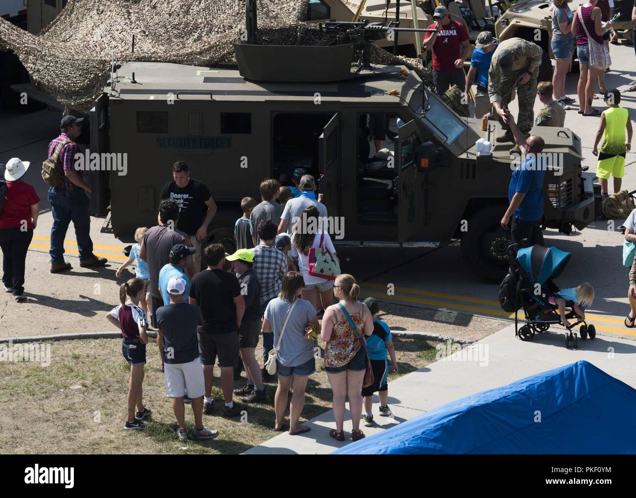 Airshow attendees view a Team Minot security forces’ armored vehicle during Northern Neighbors Day Air and Space Show at Minot Air Force Base, North Dakota, Aug. 4, 2018. The event featured aerial demonstrations by the U.S. Air Force Thunderbirds, Carlton Glider, B-25 Mitchell, T-33 Acemaker and more. Stock Photo