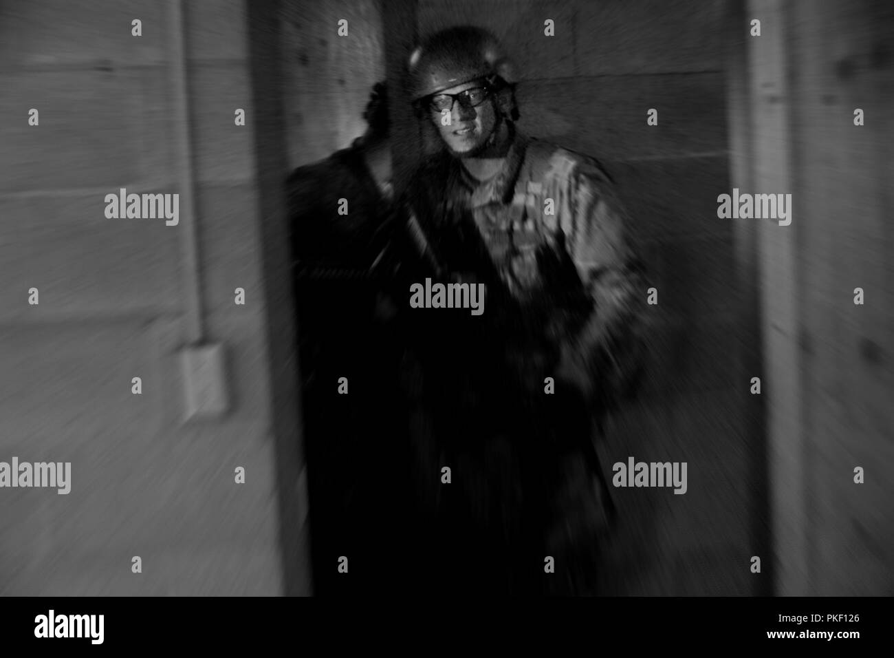 Officer candidates run through darkened hallways, simulated smoke and loud mock-machine gun fire during urban operations with the Washington Army National Guard consolidated OCS Phase III training on Joint Base Lewis-McChord, July 31, 2018.  (Washington National Guard Stock Photo