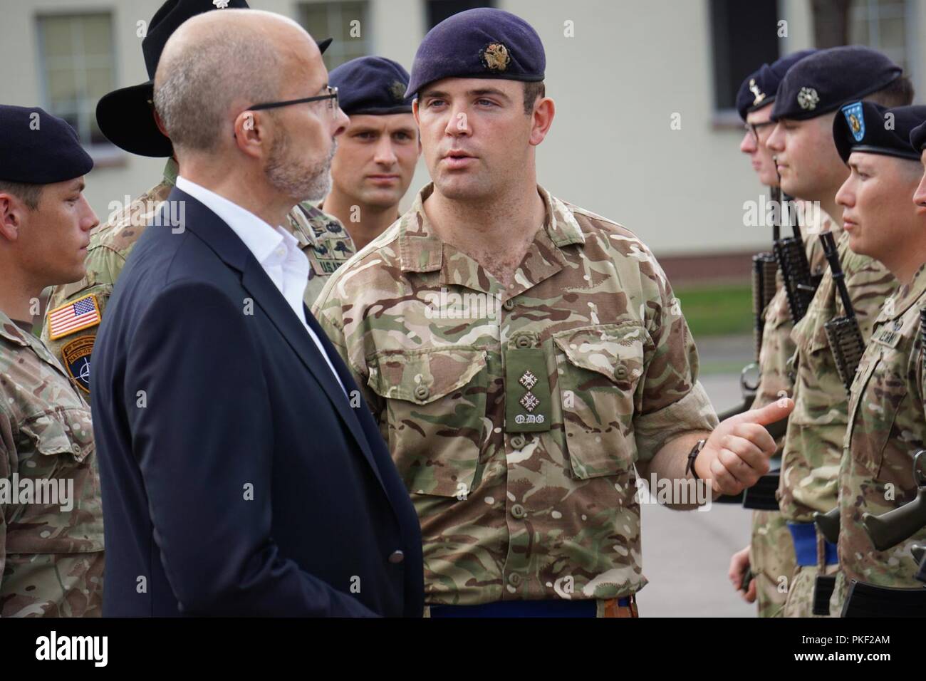 Lt. Charlie Byrd, Troop and Course Leader, Queen's Dragoon Guard, British Armed Forces, escorts Jonathon Knot, U.K. Ambassador to Poland, as he conducts a Troop inspection at a graduation ceremony at the Bemowo Piskie Training Area, Poland, August 6, 2018. The graduation ceremony marked the conclusion of a British run two course for Potential Non-Commissioned Officer (PNCO) Candidates. Stock Photo