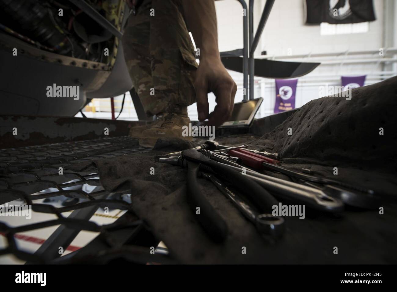 A 27th Special Operations Aircraft Maintenance Squadrn Airman reaches for his tools whilst working on a MC-130J Commando II engine at Cannon Air Force Base, N.M., Aug. 1, 2018. Airmen involved with the 9th Aircraft Maintenance Unit at Cannon work with refueling aircraft to ensure that not only that mission is accomplished, but the dozens of others that require in-flight refueling. Stock Photo