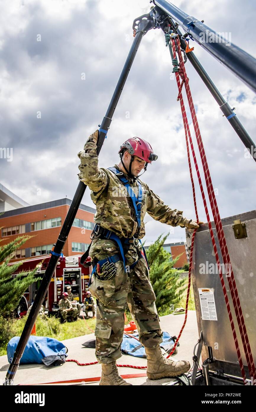 FORT BELVOIR, VA.-- (August 1, 2018)--Members of the 911th Technical Rescue Engineer Company make entry into a manhole behind the Belvoir Hospital and extract simulated patients during a training exercise August 1, 2018.  The 911th Technical Rescue Engineer Company, formerly the MDW (Military District of Washington) Engineer Company, is the only technical rescue company in the Department of Defense. It specializes in Urban Search and Rescue.  The 911th is stationed at Fort Belvoir and is best known for its response to The Pentagon following the September 11 attacks in 2001.  The company is min Stock Photo