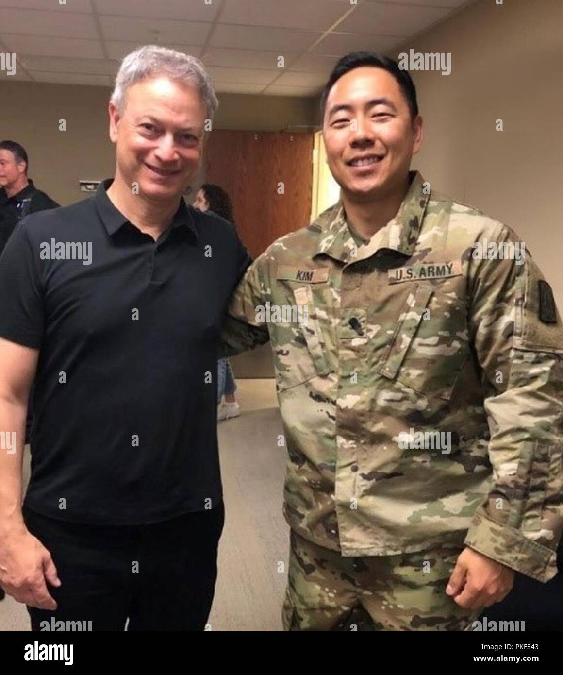 Spc. Andy Kim shares a moment with actor Gary Sinese during a visit to Brooke Army Medical Center. Stock Photo