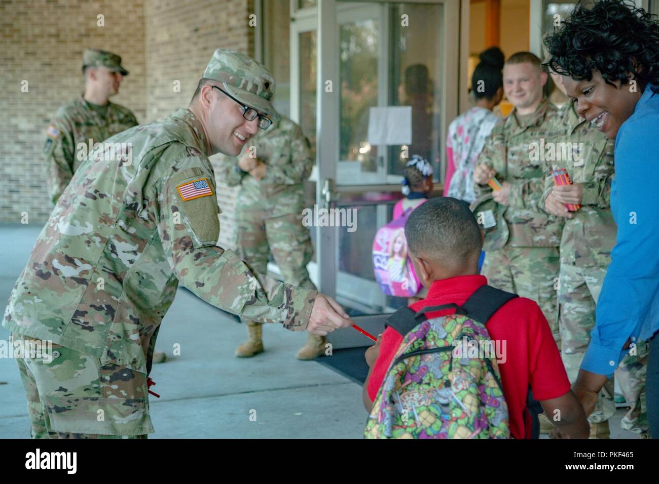 Spartan Soldiers of 6th Squadron, 8th Cavalry Regiment, 2nd Armored Brigade Combat Team, 3rd Infantry Division, welcome incoming children on their first day of school in Hinesville, Ga., Aug 6. Stock Photo