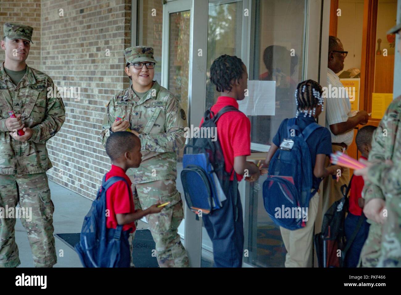 Spartan Soldiers of 6th Squadron, 8th Cavalry Regiment, 2nd Armored Brigade Combat Team, 3rd Infantry Division, welcome incoming children on their first day of school in Hinesville, Ga., Aug 6. Stock Photo