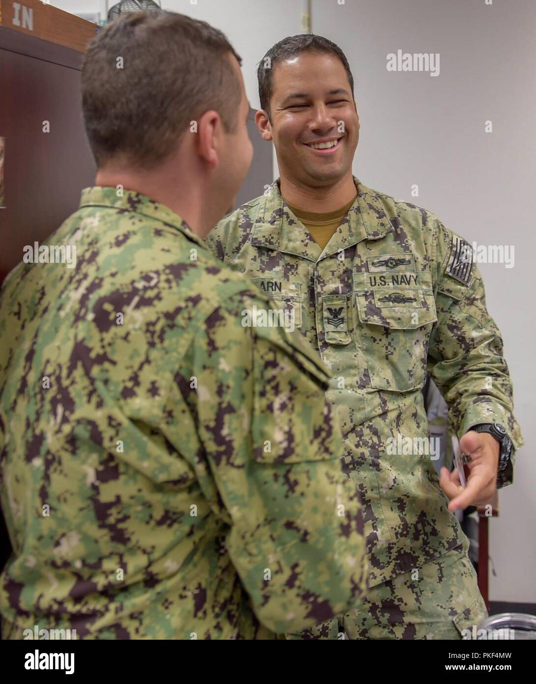 Fla. (Aug. 7, 2018) Cryptologic Technician (Technical) 1st Class Mathew Shearn, a training manager at the Center for Information Warfare Training (CIWT), receives news of his selection to the rank of chief petty officer from CIWT’s commanding officer, Capt. Nick Andrews. Fifty-five staff members across the CIWT domain were selected for promotion. Stock Photo