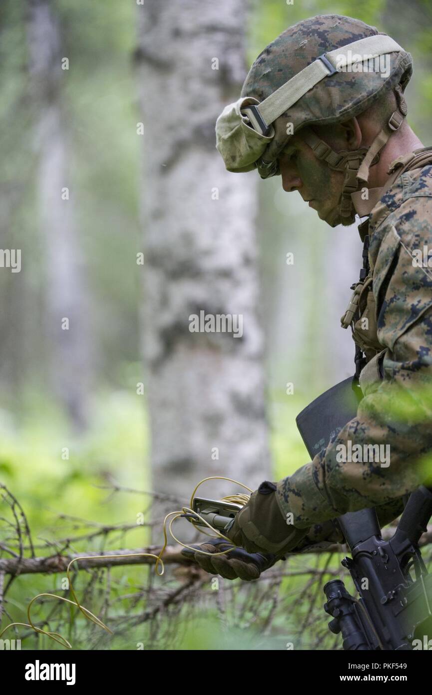 U.S. Marine Corps Lance Cpl. Cole Cunningham, a mortarman with 3rd Battalion, 23rd Marine Regiment, unravels detonation cord while setting up a simulation claymore mine during the 4th Marine Division Super Squad Competition at Joint Base Elmendorf-Richardson, Alaska, Aug. 4, 2018. During the competition, squads from 1st and 3rd Battalions, 23rd Marine Regiment and 1st Battalion, 24th Marine Regiment, exercised their technical and tactical proficiencies by competing in events that highlighted offensive/defensive operations, patrolling techniques, combat marksmanship, physical endurance and smal Stock Photo