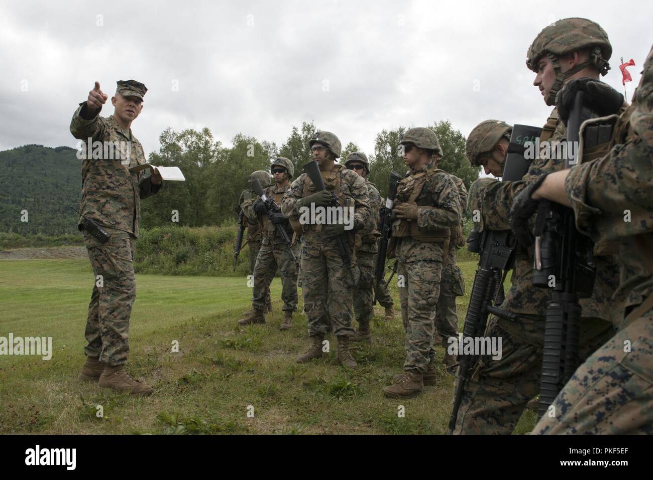 U.S. Marine Corps Sgt. Andrew Wolfla, assigned to 4th Marine Division, delivers a range safety brief to Marines with Charlie Company, 1st Battalion, 23rd Marine Regiment before they conduct a live-fire marksmanship event during the 4th Marine Division Super Squad Competition held at Joint Base Elmendorf-Richardson, Alaska, Aug. 6, 2018. During the multi-day competition, squads from 1st and 3rd Battalions, 23rd Marine Regiment and 1st Battalion, 24th Marine Regiment, exercised their technical and tactical proficiencies by competing in events that highlighted offensive/defensive operations, patr Stock Photo