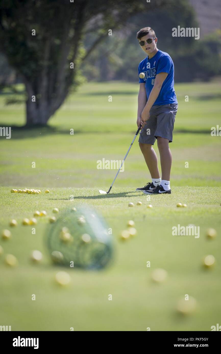 Brandon Garner, golfer with the Marine Corps Community Services Youth  Sports Golf Camp, watches a golf ball after he chips at the Marine Memorial  Golf Course at Marine Corps Base Camp Pendleton,