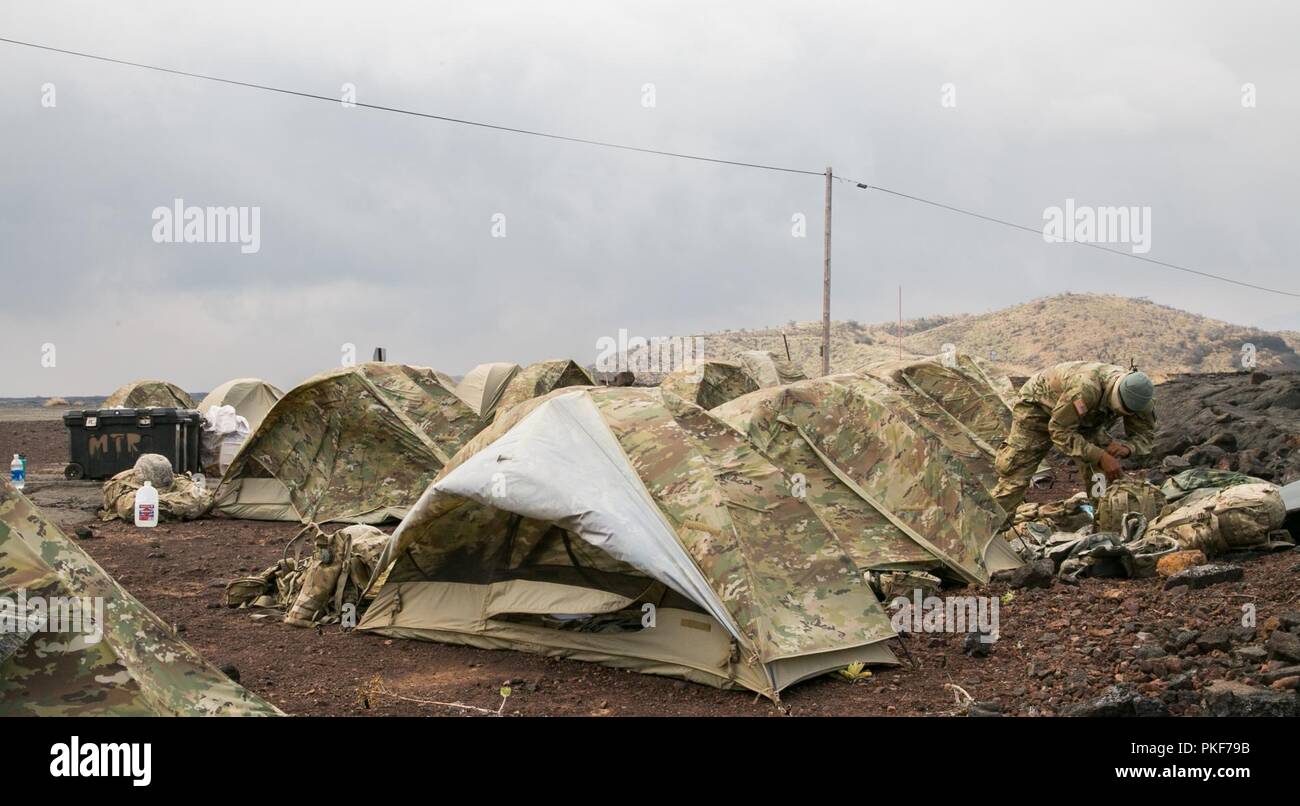 Spc. Jay Jacob, right, an indirect fire infantryman of California National Guard's B Company, 1st Battalion-160th Infantry Regiment, 40th Infantry Division, left the summer warmth of his Los Angeles home for the chilly evenings atop Pohakuloa Training Area, July 30, 2018, in Hilo, Hawaii. The guardsmen are in Hawaii to conduct their annual training. Stock Photo