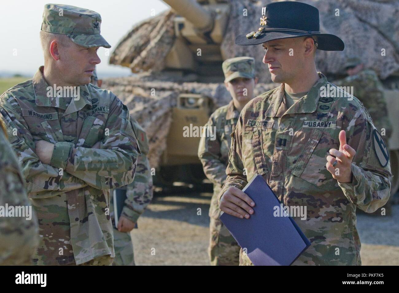 U.S. Army Capt. Patrick R. Glazebrook, the commander of Comanche Troop, 1st Squadron, 7th Cavalry Regiment, 1st Armored Brigade Combat Team, 1st Cavalry Division, and U.S. Army Col. Todd R. Wasmund, Deputy Commanding Officer (Support) for the 1st Infantry Division, discuss plans for a unit training observation day at the central training area in Várpalota, Hungary, Aug. 3, 2018. Comanche Troop invited the U.S. Ambassador to Hungary David B. Cornstein, mayors from the towns surrounding the training area, Hungarian soldiers and local Hungarian media to view static displays and demonstrations of  Stock Photo