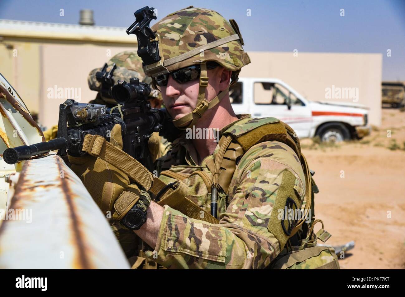 Sgt. Donald Montgomery, an infantryman, with Company C, 2nd Battalion, 137th Infantry Regiment, pulls security while conducting squad situational training exercise rehearsals at the Army Central Command Readiness Training Center, Camp Buehring, Kuwait, on Aug. 8, 2018. The 2-137 IN is deployed to Kuwait in support of Operation Spartan Shield. Stock Photo