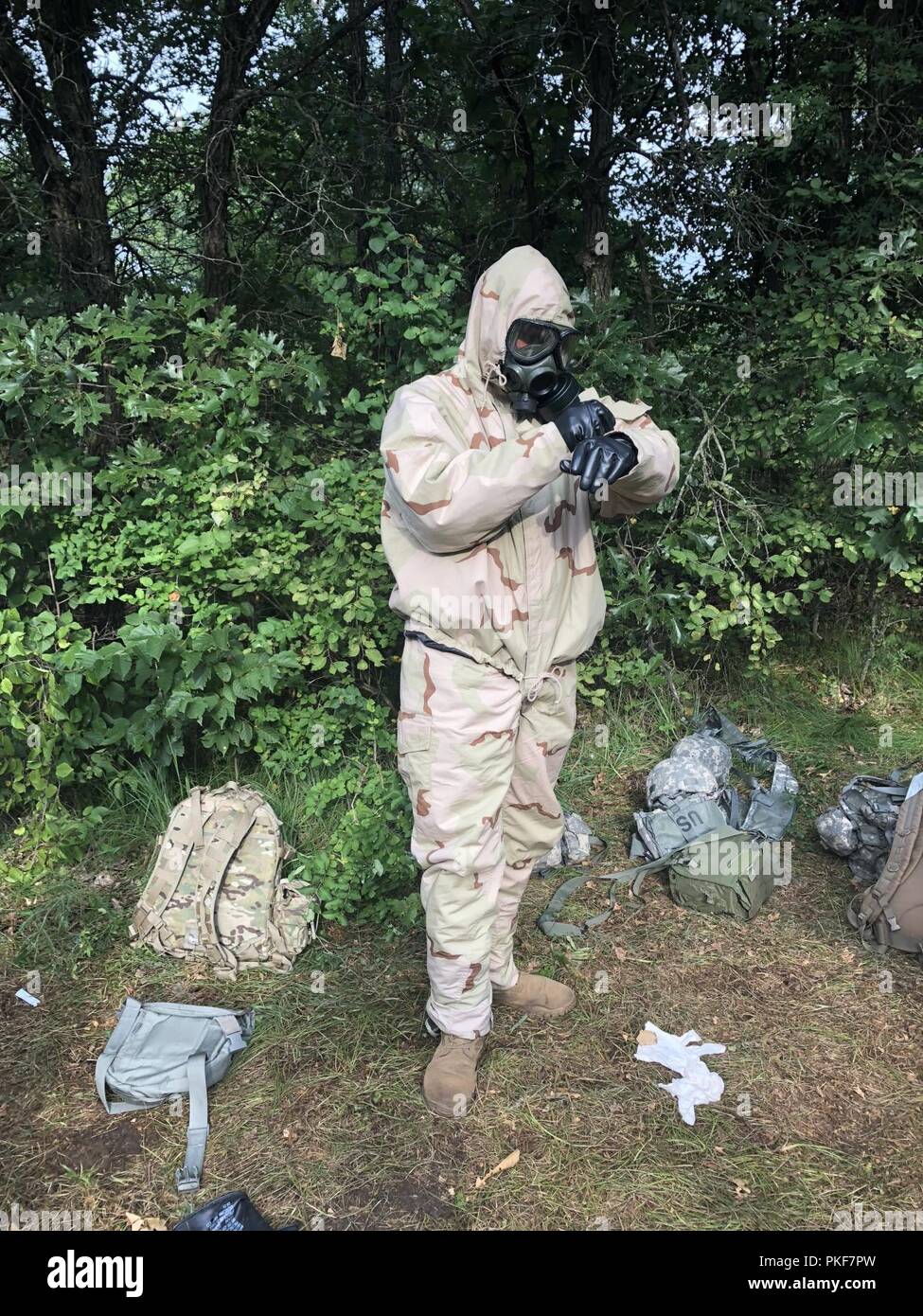 Chaplin Candidate Ramsey of the 382nd Combat Sustainment Support Battalion, based at Joint Base Lewis–McChord, WA., practices dawning his MOPP gear during Lethal Warrior training at Ft. McCoy, WI., during CSTX 86-18-02, August 8, 2018. Ramsey joined the reserves to do his part to reduce suicides amongst service members. CSTX 86-18-02 is a Combat Support Training Exercise that ensures America's Army Reserve units and Soldiers are trained and ready to deploy on short-notice and bring capable, combat-ready, and lethal firepower in support of the Army and our joint partners anywhere in the world. Stock Photo
