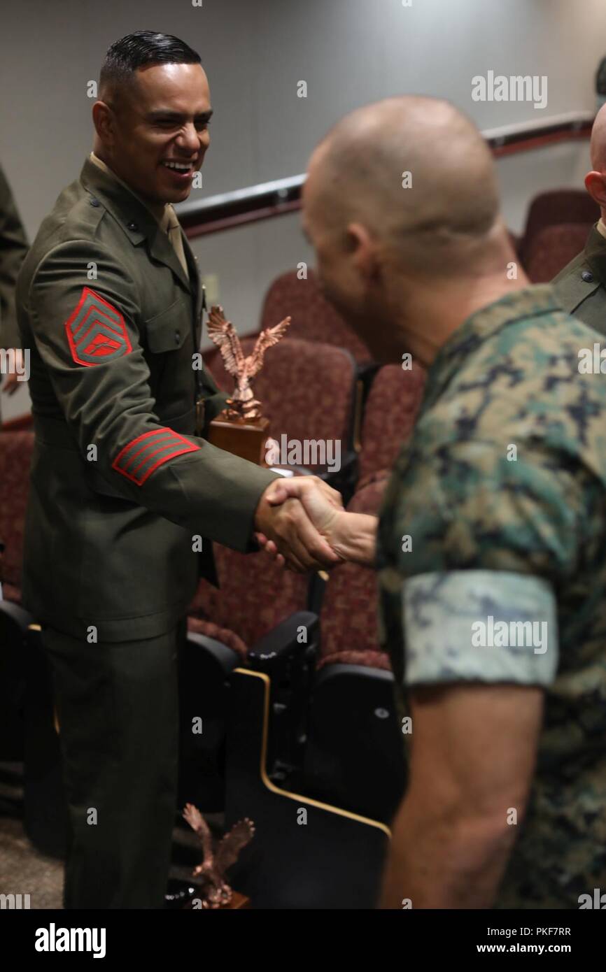 U.S. Marine Corps Staff Sgt. Roberto C. Jimenez, left, an instructor assigned to Personnel Administration School (PAS), Marine Corps Combat Service Support Schools shakes hands with Marines as they congratulate him during the Instructor of the Year Ceremony at Camp Johnson, N.C., August 6, 2018. The Instructor of the Year Ceremony recognizes instructors who have demonstrated sustained superior performance in their instructional abilities. Stock Photo