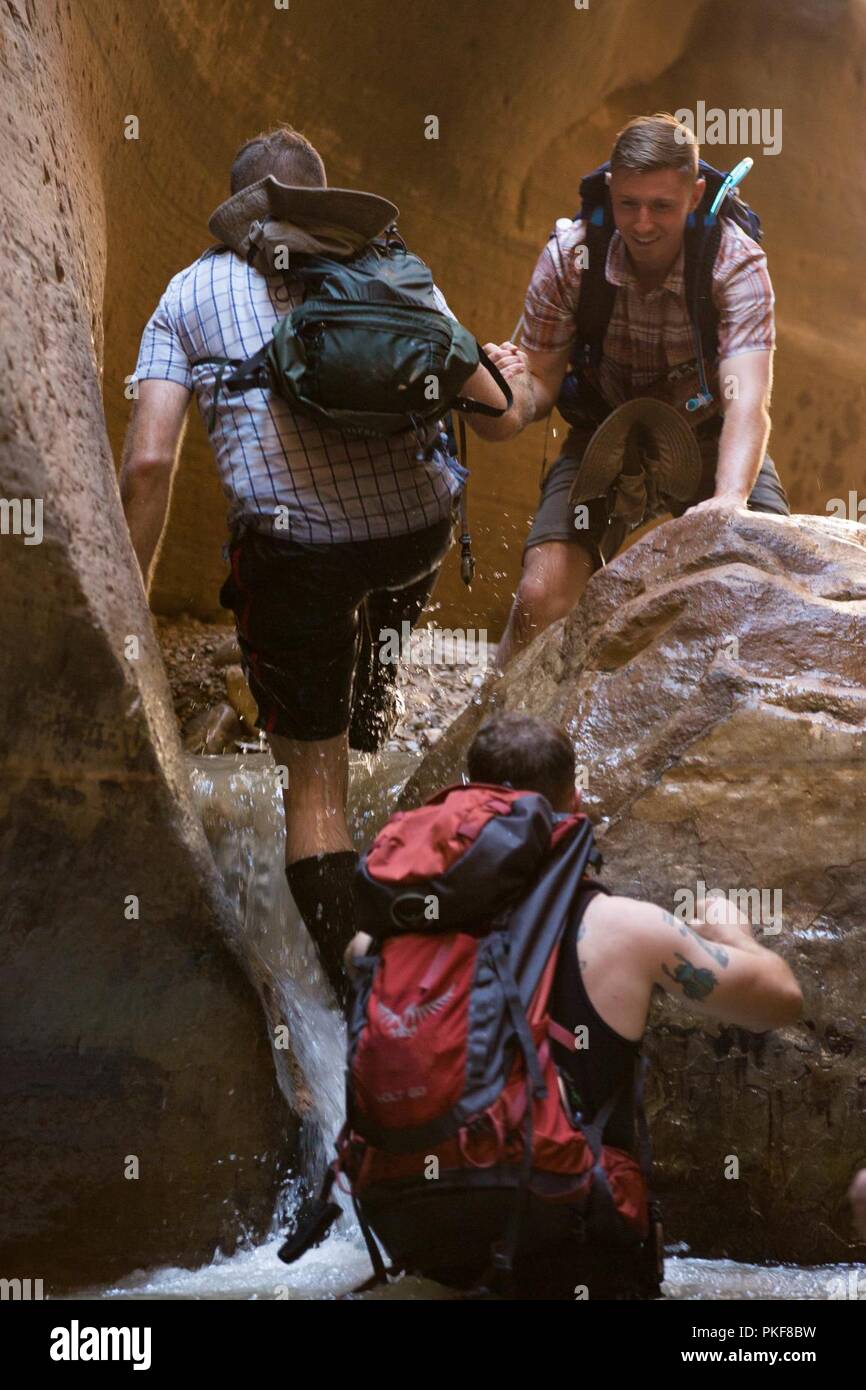U.S. Marine Corps Sgt. Brehm Rhett (top), ground radio repairman, 1st Intelligence Battalion, I Marine Expeditionary Force-Information Group, helps Marines traverse terrain during a Single Marine Program (SMP) trip at Zion National Park, Utah, Aug. 4, 2018.  SMP provides service members with opportunities to challenge their physical fitness in unique ways and bond with other service members who are interested in similar activities. Stock Photo