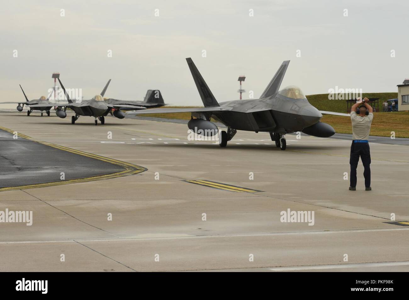 U.S. Air Force F-22 Raptors from the 95th Fighter Squadron, 325th Fighter Wing at Tyndall Air Base, Fla., arrive at Spangdahlem Air Base, Germany, Aug. 8, 2018. The 95th FS is deployed to Europe for several weeks to conduct training with other European-based aircraft as part of a Flying Training Deployment. Forward locations enable collective defense capabilities and provide U.S. and NATO the strategic and operational breadth needed to deter adversaries and assure our allies and partners. Stock Photo