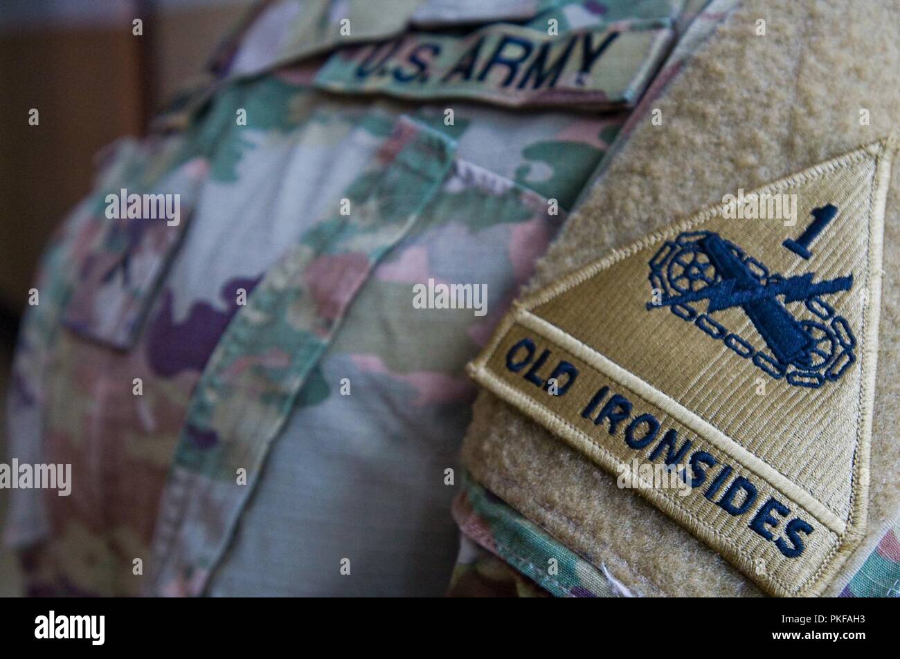 U.S. Army Pvt. Yamile Amarante, a postal clerk with the 178th Human Resources Company, 16th Special Troops Battalion, 1st Armored Division Sustainment Brigade, 1st Armored Division, shows off her unit patch “Old Ironsides,” Zagan, Poland, July 25, 2018. Soldiers with the 178th HRC work to provide postal support to Soldiers and civilians within the Atlantic Resolve area of operations. Stock Photo