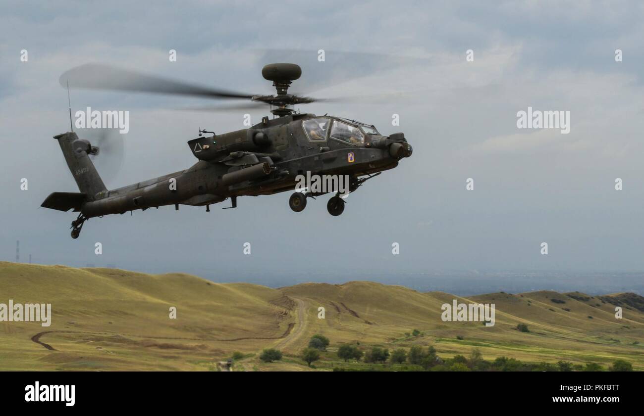 An AH-64 Apache helicopter with 1st Battalion, 3rd Aviation Regiment hovers above Vaziani Training Area, Georgia, during a combined arms live fire exercise led by 2nd Battalion, 5th Cavalry Regiment, Aug. 12, 2018. 2-5 CAV participated in Noble Partner 2018, a Georgian Armed Forces and U.S. Army Europe cooperatively-led exercise in its fourth iteration intended to support and enhance the readiness and interoperability of Georgia, the U.S. and participating nations during a multinational training operation. Stock Photo