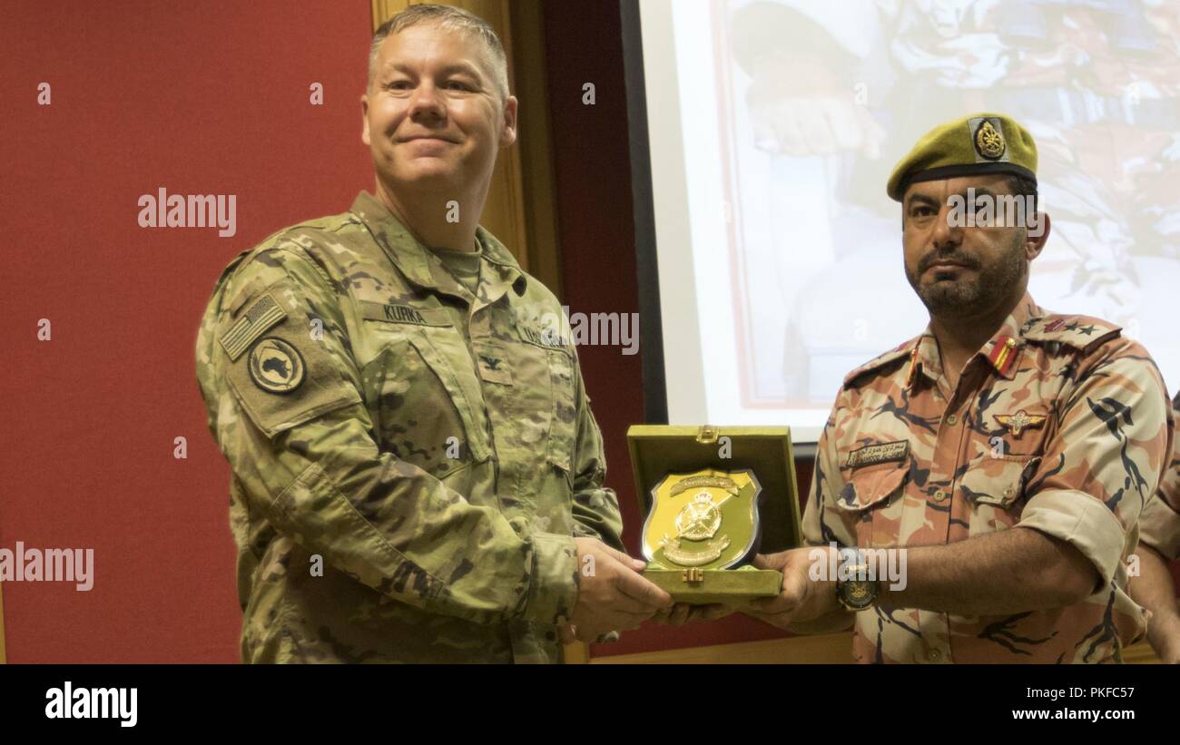 U.S. Army Col. Jeffrey Kurka, commander of the 157th Military Engagement Team, Wisconsin Army National Guard, attached to U.S. Army Central, accepts a plaque from Royal Army of Oman Col. Said Hamood Al-Jabri at a ceremony held to celebrate a successful engagement between the two military forces in Haima, Oman, Aug. 9, 2018. The engagement focused on sharing best practices and techniques for increasing border security, and also created an opportunity for U.S. Army Soldiers to build relationships with partner nation forces. Stock Photo