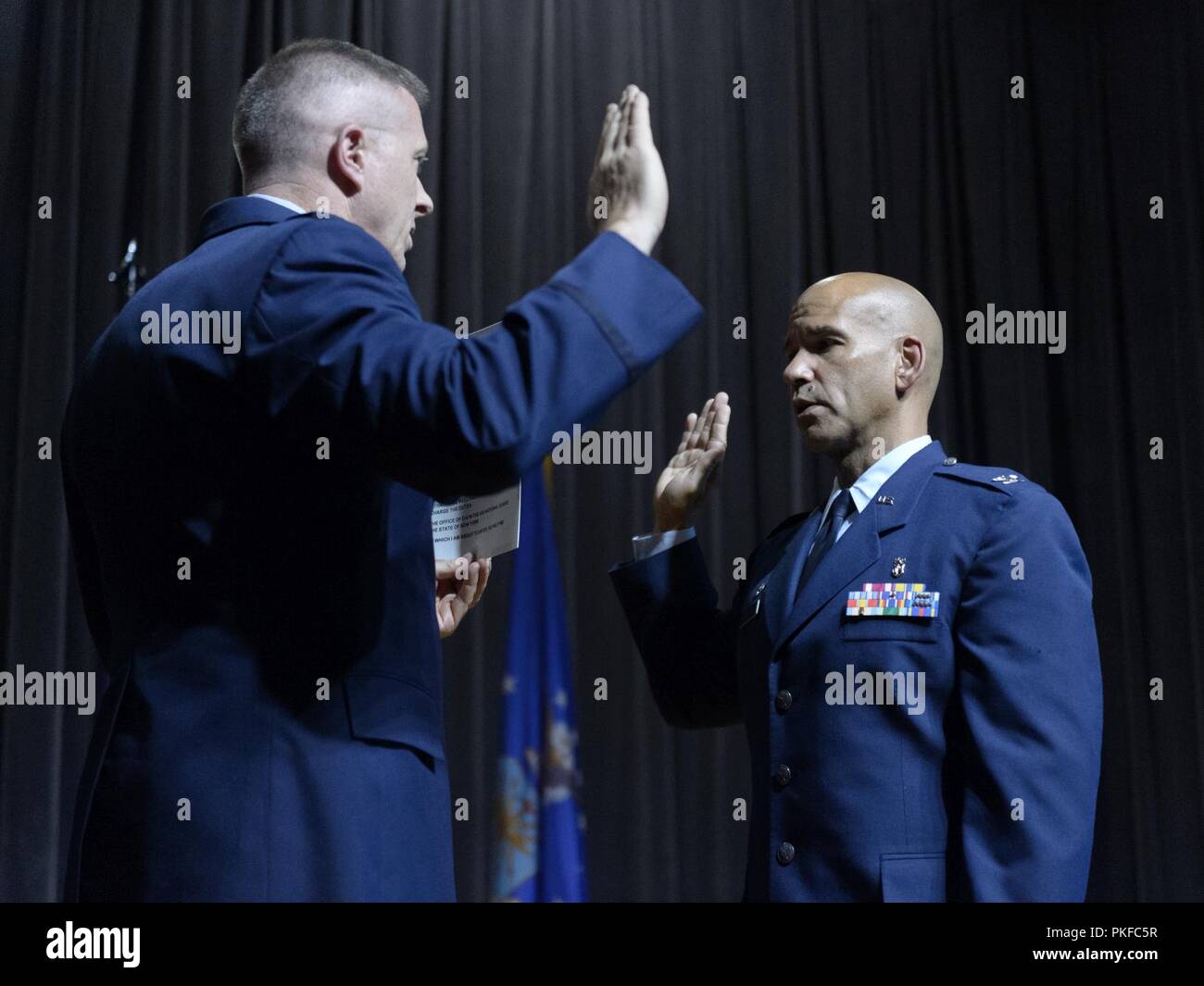Col. Robert Kilgore, commander of the 107th Attack Wing, New York National Guard, administers the colonel's charge to Col. Eric Laughton, commander of the 107th Medical Group, 107th ATKW, during a promotion ceremony at Niagara Falls Air Reserve Station, N.Y., Aug. 11, 2018. Laughton is promoted after having recently taken command of the 107th MDG. Stock Photo