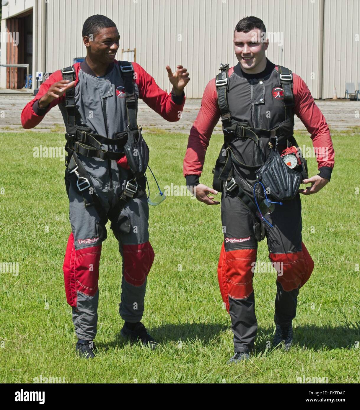 U.S. Air Force Airman 1st Class Gabriel Ford, left, and Airman 1st Class Tyler Sims, 20th Equipment Maintenance Squadron stock pile management crew chiefs, discuss their experiences following a “leap of faith” skydiving event in Chester, S.C., Aug. 11, 2018. There are three steps that prepare Airmen to take the leap of faith which are: doing homework, facing obstacles or fears and not going through things alone. Stock Photo