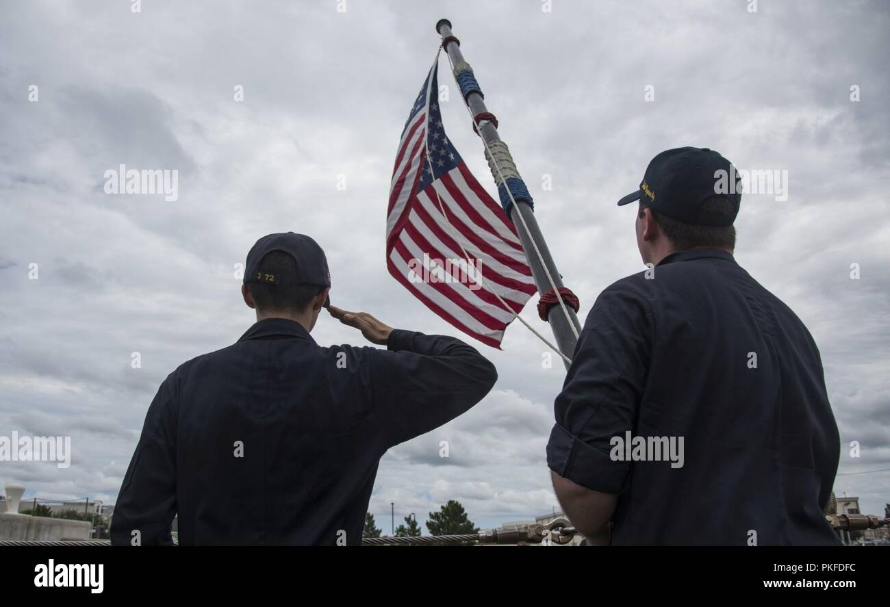 Va. (Aug. 03, 2018)  Fire Controlman (Aegis) 3rd Class David Billings, from Houston, left, and Information Systems Technician 2nd class Alexander Brandt, from Little Rock, Ark., raise the national ensign on the fantail of the guided-missile cruiser USS Vella Gulf (CG 72). Vella Gulf is currently pier side at Norfolk Naval Station. Stock Photo