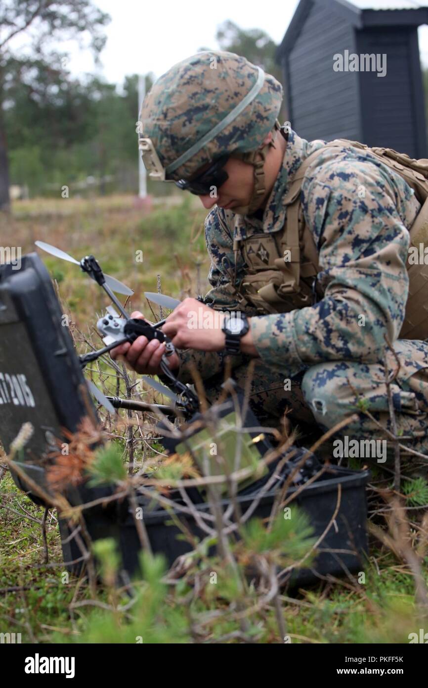 A U.S. Marine with Marine Rotational Force-Europe 18.1 assembles a Small Unmanned Aerial System during a platoon-supported attack at Giskas, Norway, Aug. 8, 2018. The SUAS uses a camera to capture real-time surveillance while flying overhead, allowing Marines to track movement and relay information to a squads from a distance. Stock Photo