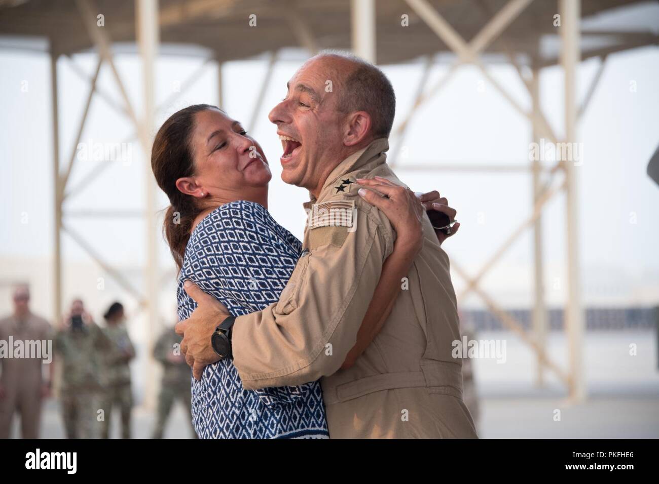 U.S. Air Force Lt. Gen. Jeffrey L. Harrigian, Commander U.S. Air Forces Central Command, embraces his wife after his final flight, or “fini flight,” at Al Dhafra Air Base, August 8, 2018. The general is an Air Force Weapons School graduate and a command pilot with more than 4,100 flight hours in the F-22, F-15C, A/OA-37 and MQ-1. Stock Photo