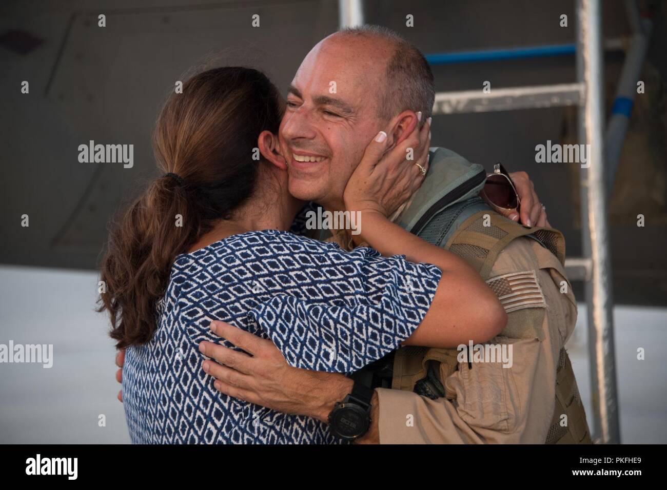 U.S. Air Force Lt. Gen. Jeffrey L. Harrigian, Commander U.S. Air Forces Central Command, hugs his wife after his final flight, or “fini flight,” at Al Dhafra Air Base, August 8, 2018. Lt. Gen. Harrigian took command of AFCENT in July 2016, and has led U.S. and Coalition air operations against ISIS as part of Operation Inherent Resolve in Iraq and Syria and against the Taliban and terrorist networks in Afghanistan as part of Operation Freedom’s Sentinel and the NATO Resolute Support mission in Afghanistan. Stock Photo