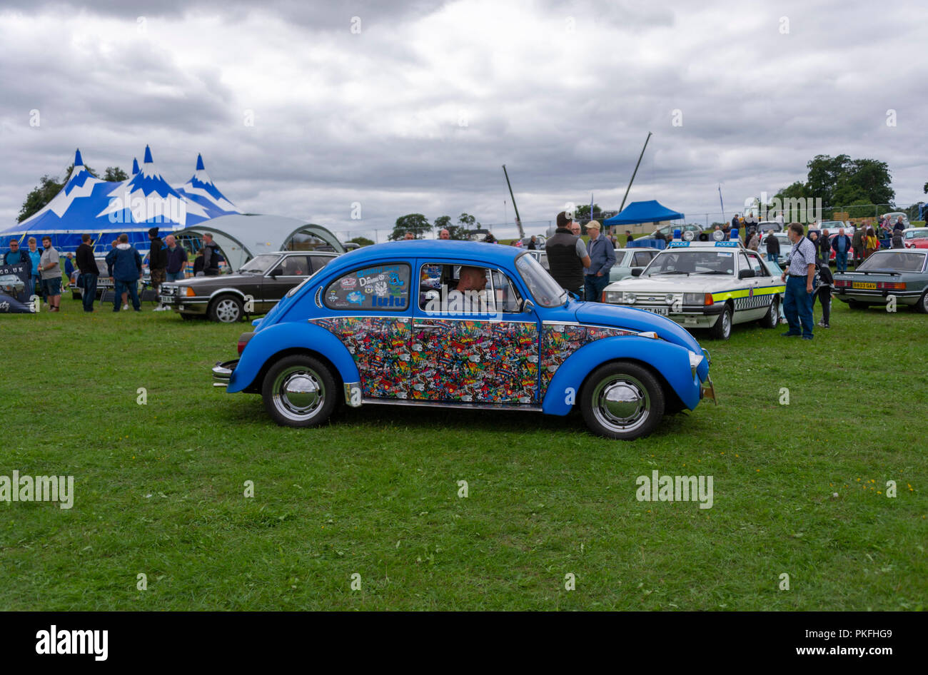 VW Beetle with cartoons painted on the side at Knebworth House Knebworth UK Stock Photo