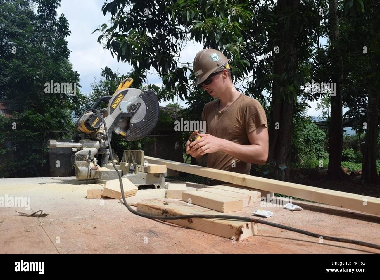PALAWAN, Philippines (August 09, 2018) Builder Construction Apprentice Tristain Hieb, assigned to Naval Mobile Construction Battalion (NMCB) 5, measures the length of a piece of lumber to ensure he has the right measurement prior to cutting out studs for formwork. NMCB 5 is forward deployed to execute construction, humanitarian and foreign assistance, and theater security cooperation support of United States Pacific Command. Stock Photo
