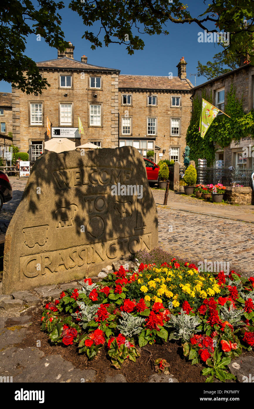 UK, Yorkshire, Wharfedale, Grassington, The Square, floral planting at town name stone Stock Photo