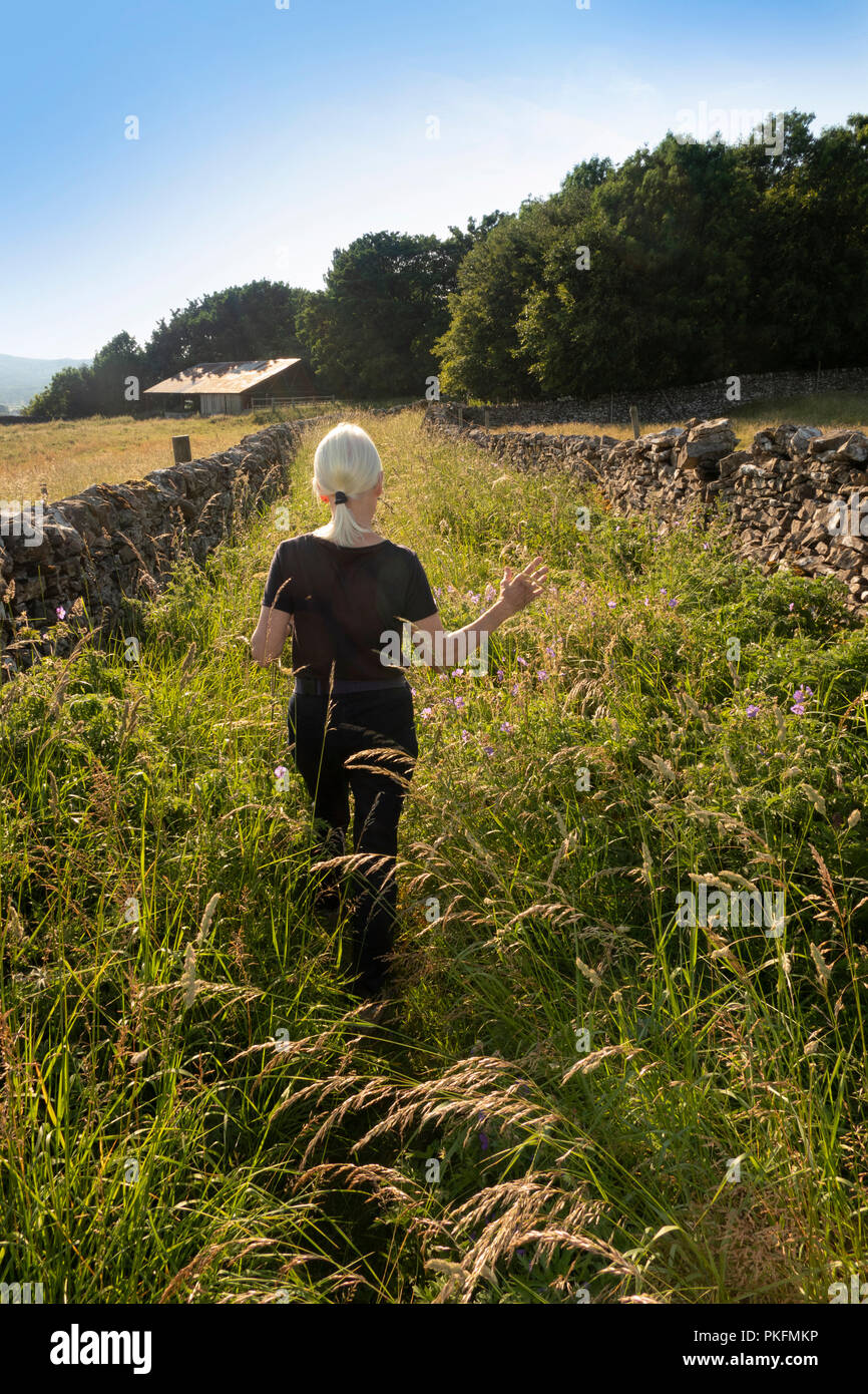 Woman walking down country lane hi-res stock photography and images - Alamy