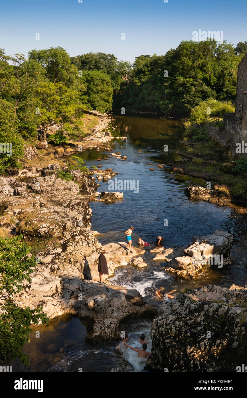 UK, Yorkshire, Wharfedale, Linton Falls, children swimming in River Wharfe during dry summer weather Stock Photo