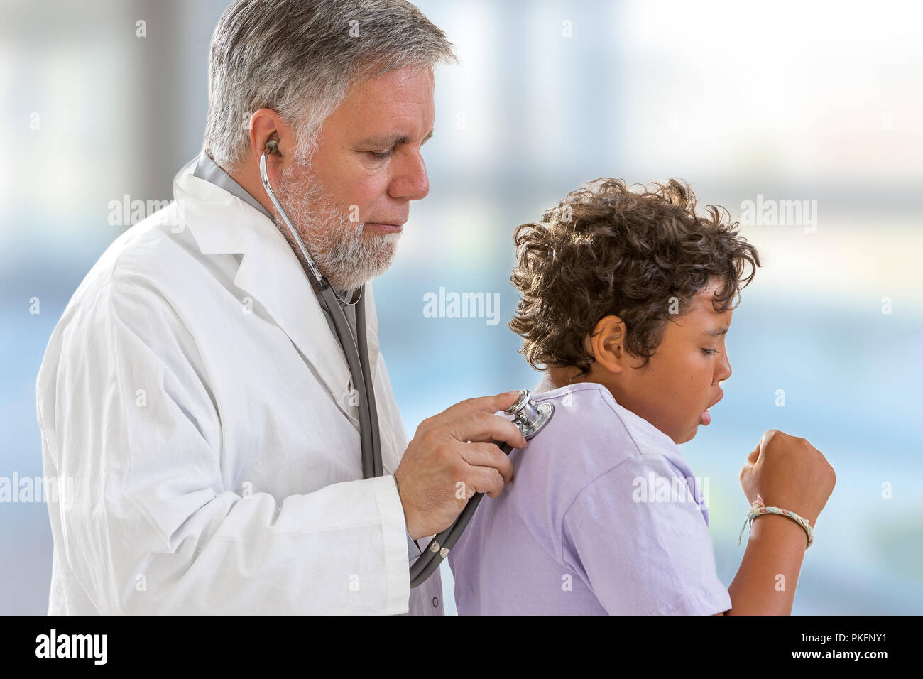 Young Teenage Check Up. Doctor Listens to Heart beat on Back with Stethoscope Stock Photo