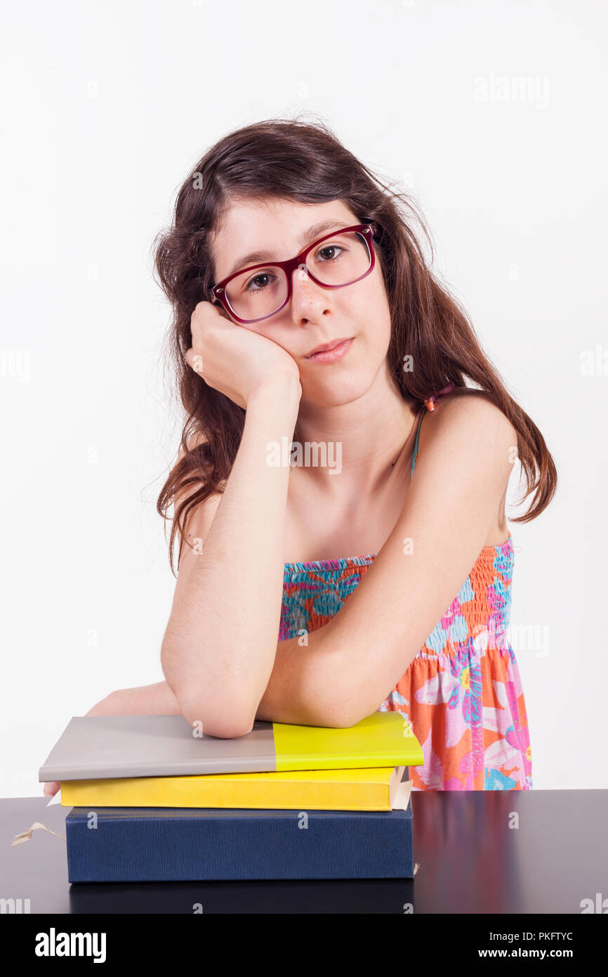 Exhausted young college girl leaning on books - tired of learning concept - School makes her bored - isolated on white background studio shoot Stock Photo