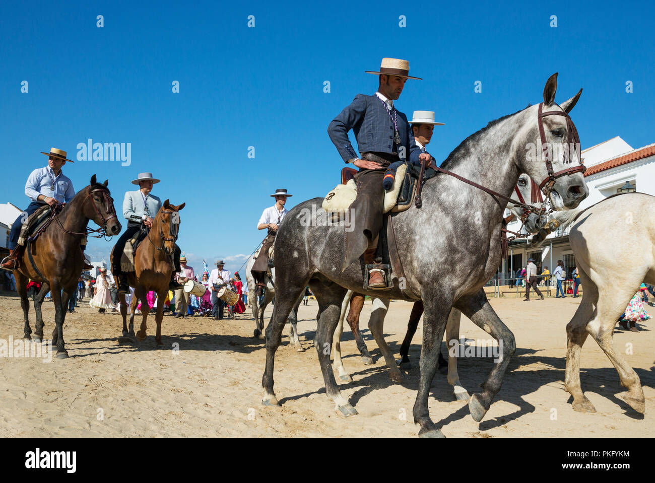 People in traditional clothes riding horses, Pentecost pilgrimage of El Rocio, Huelva province, Andalusia, Spain Stock Photo