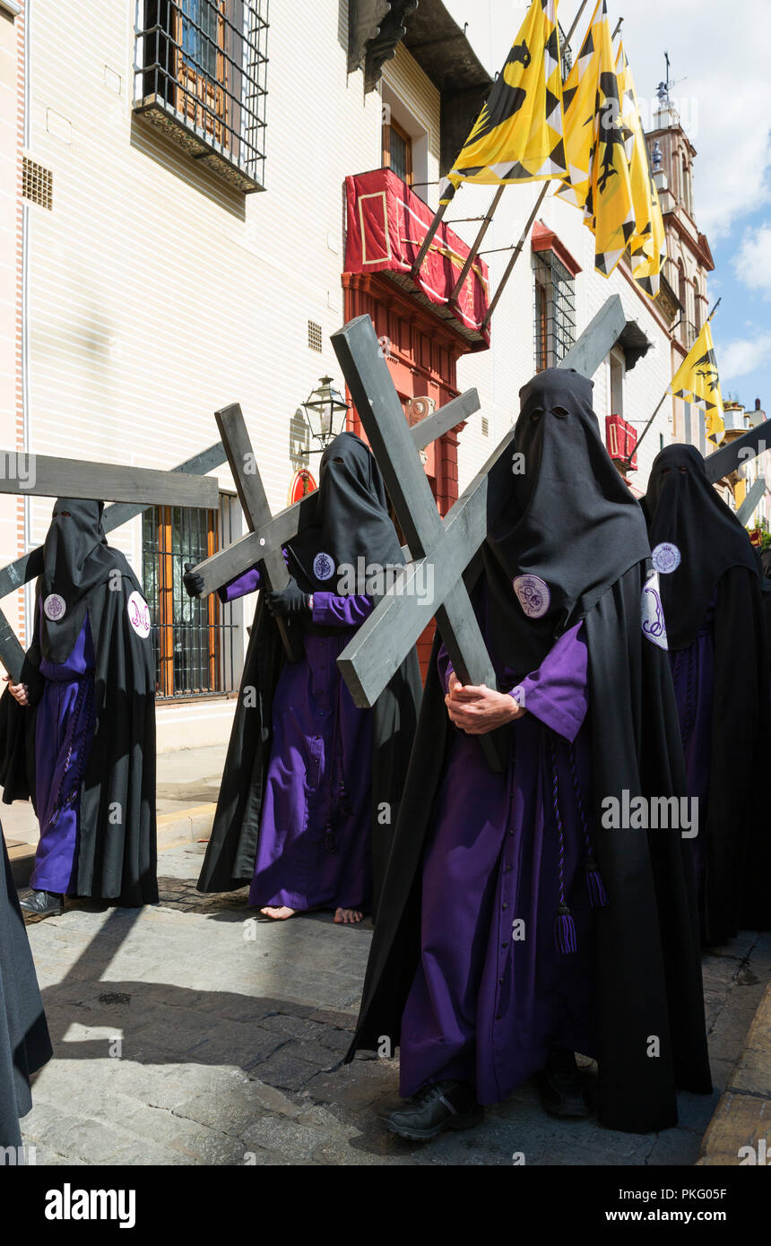 Penitents with cross at the Semana Santa, the Holy Week, Seville, Andalusa, Spain Stock Photo