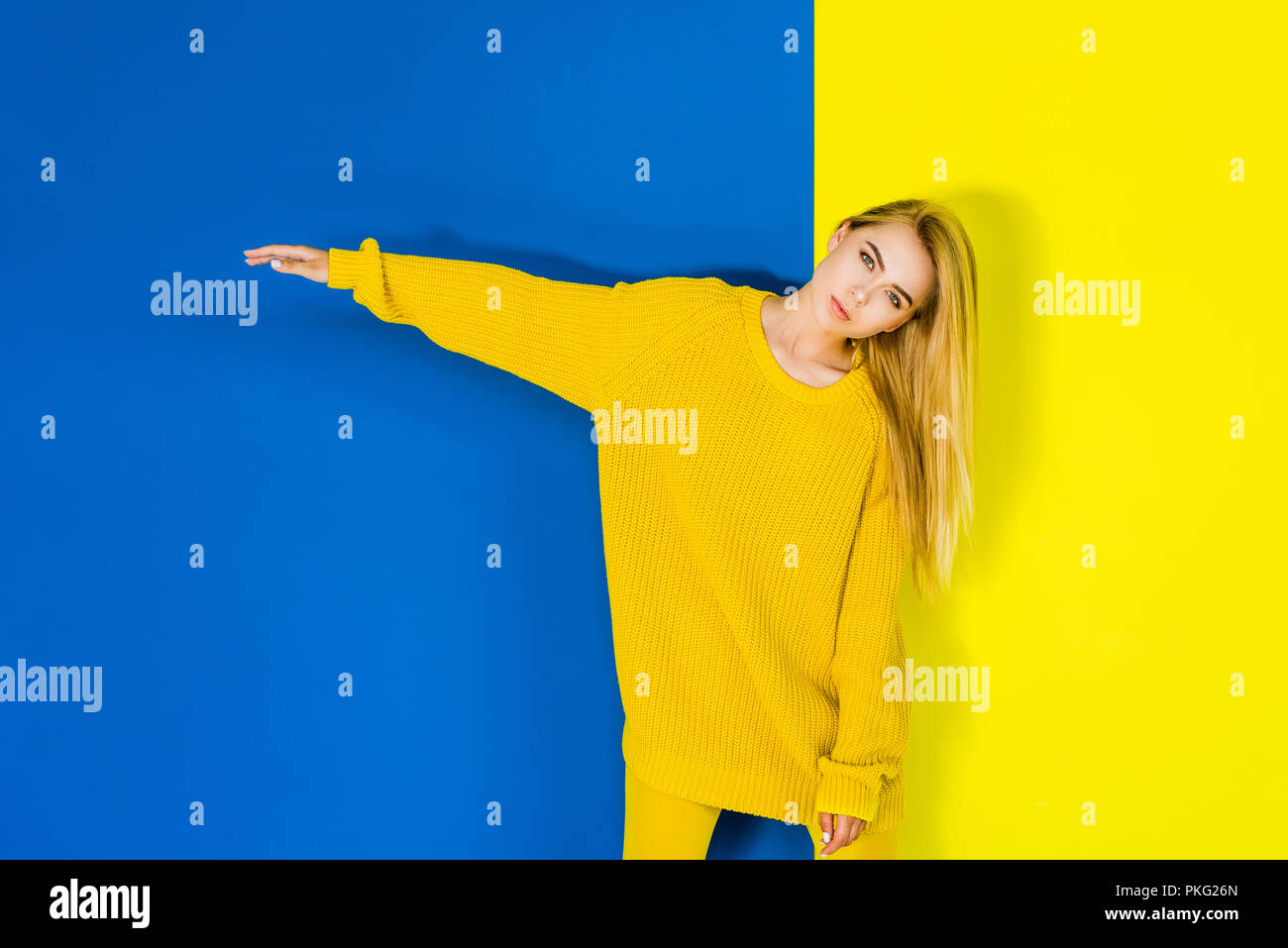 Attractive young girl posing in yellow clothes on blue and yellow ...