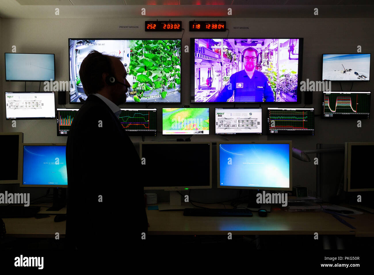 13 September 2018, Bremen: Daniel Schubert (l), EDEN ISS project manager, stands in a surveillance room at DLR (German Aerospace Center) and talks to space engineer Paul Zabel, who can be seen on one of the screens during a live connection to Antarctica. Since the beginning of the year, he has been growing lettuce, cucumbers, tomatoes, peppers and herbs near the German Neumayer III polar station. The project of the German Aerospace Center is a test run for future Mars missions.w Photo: Mohssen Assanimoghaddam/dpa Stock Photo