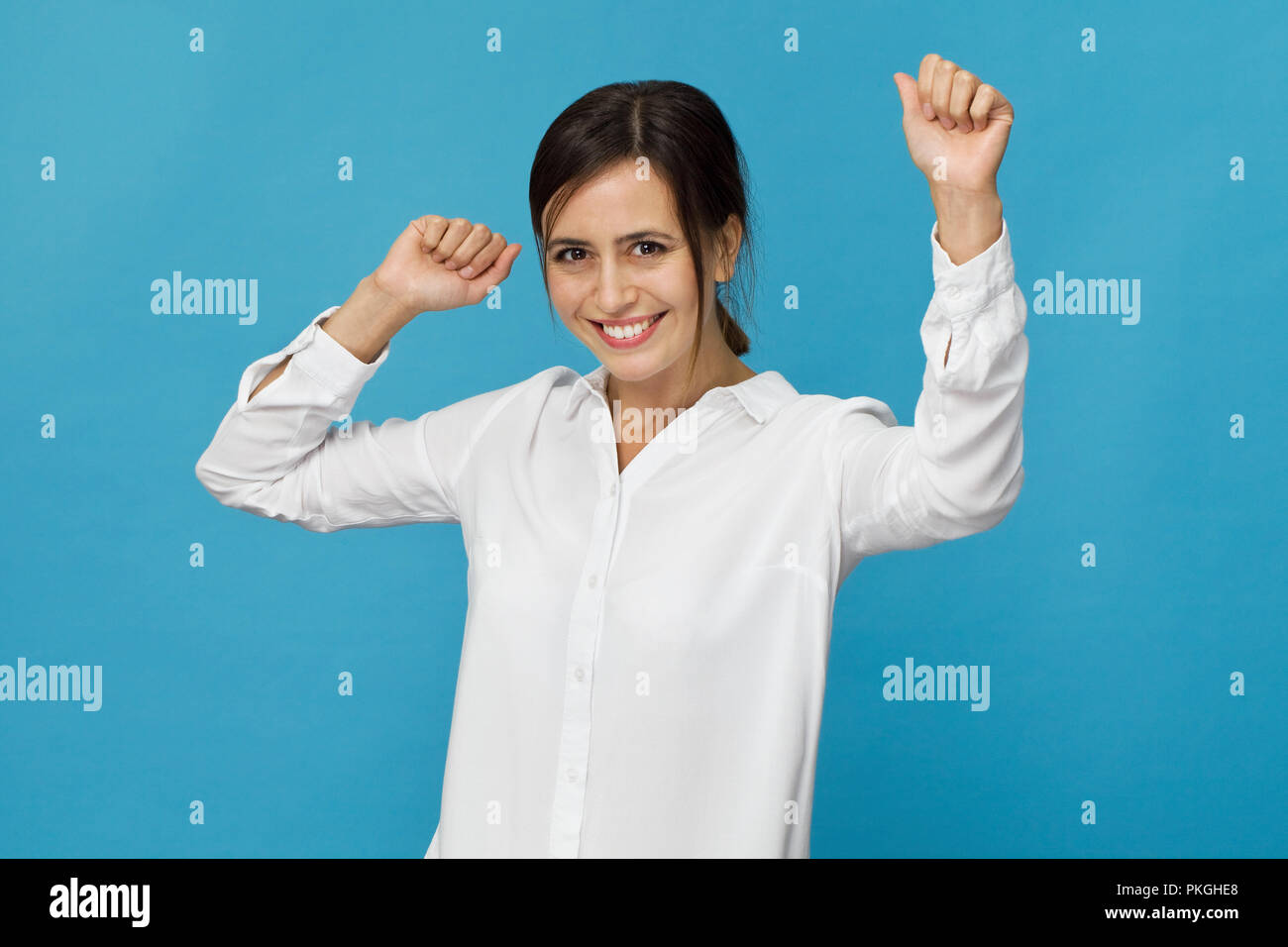 Happy young woman smiling against blue background Stock Photo