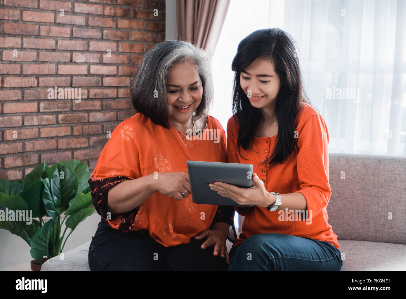 woman using tablet with her mature mom Stock Photo Alamy