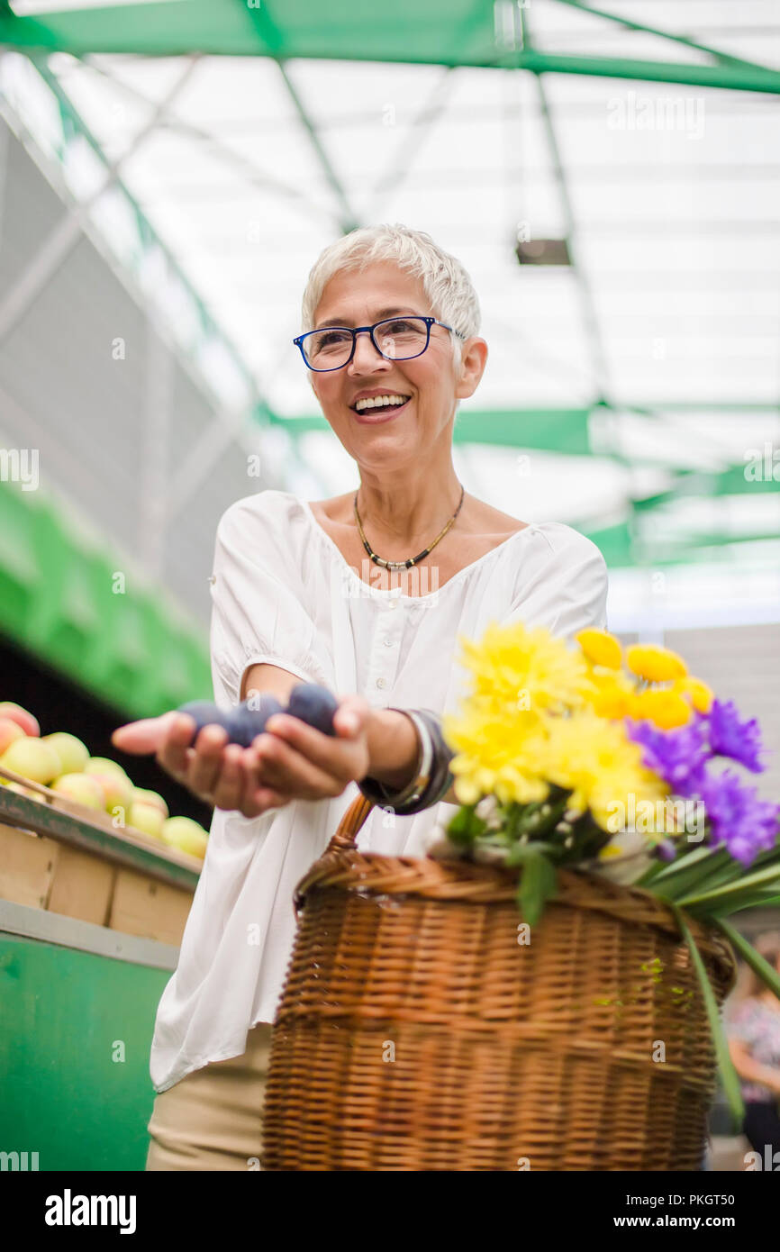 Portrait of senior woman buying fruit on market Stock Photo