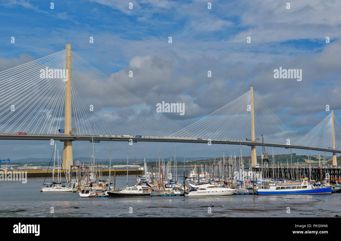 QUEENSFERRY CROSSING FIRTH OF FORTH SCOTLAND SUNLIGHT ON THE TOWERS AND CABLES AND ON YACHTS AND BOATS OF PORT EDGAR MARINA Stock Photo