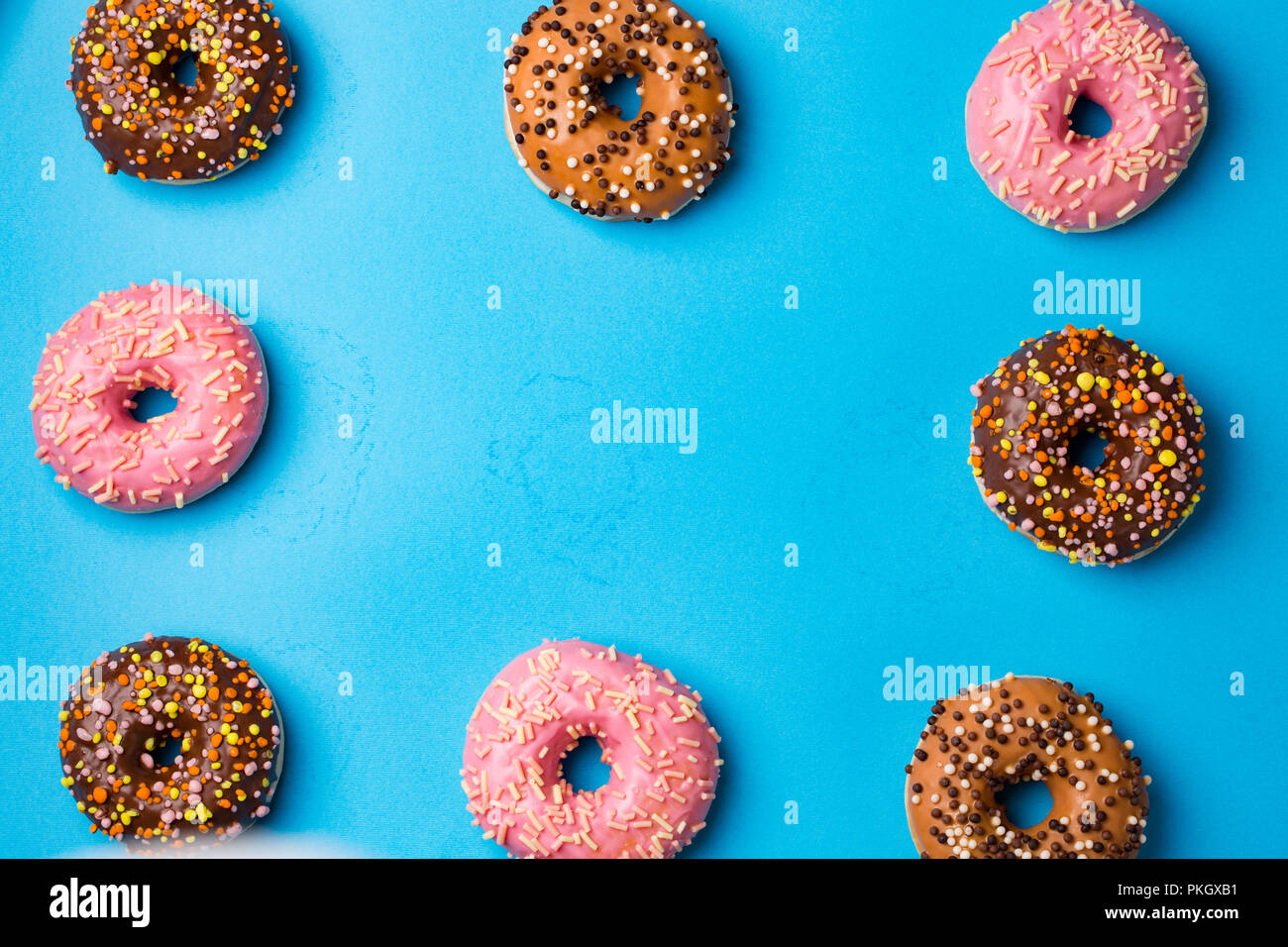 Top view of assorted donuts on blue concrete background with copy space ...