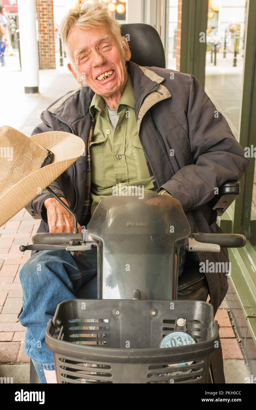 Older disabled man in an electric wheelchair in Canterbury High Street