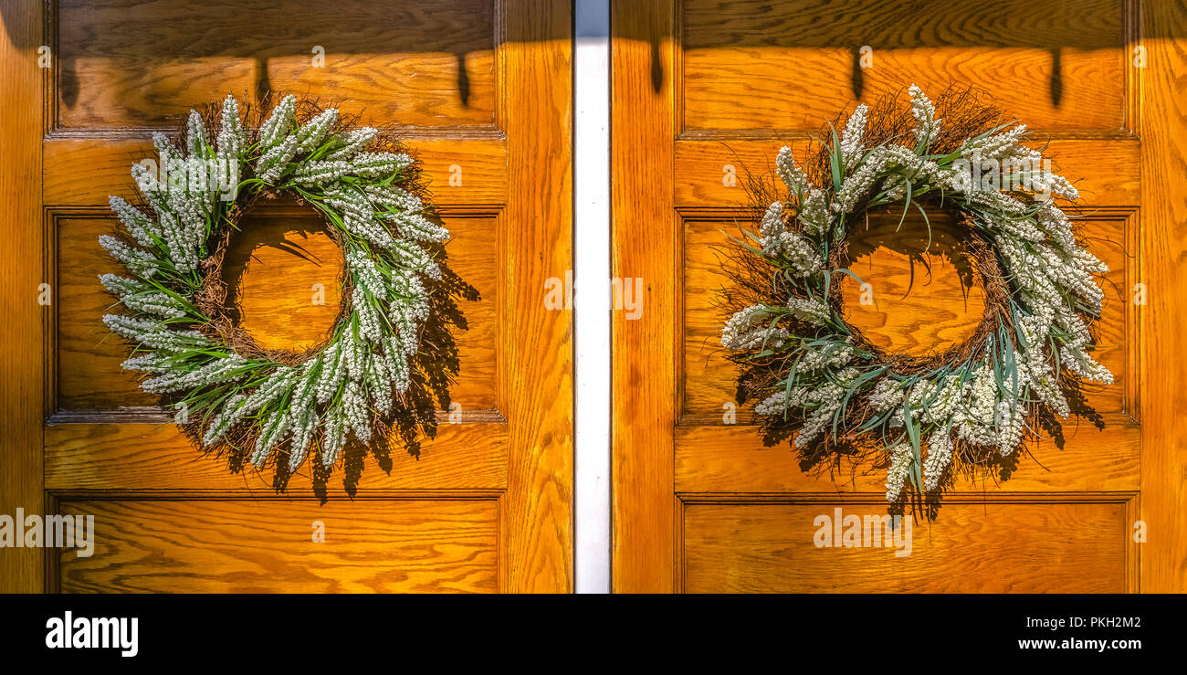 Double Wooden Front Doors With Wreath On Each Wide Stock