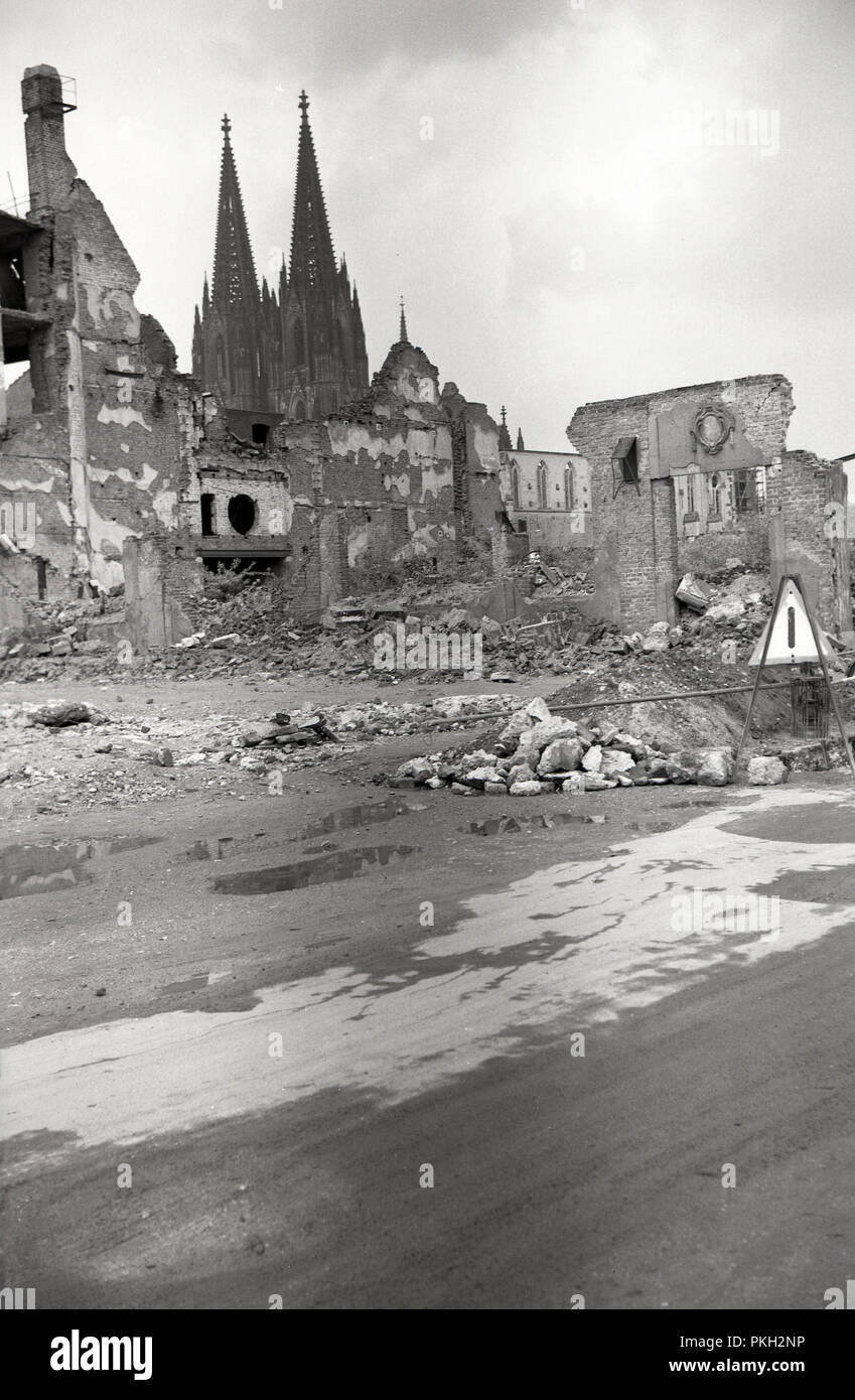 1950s, historical, Koln, Germany, a bomb site and ruined buidlings showing the damage left over after WW2. The city's famous Gothic Cathedral which was not destroyed despite the bombings, can be seen in the background. Stock Photo