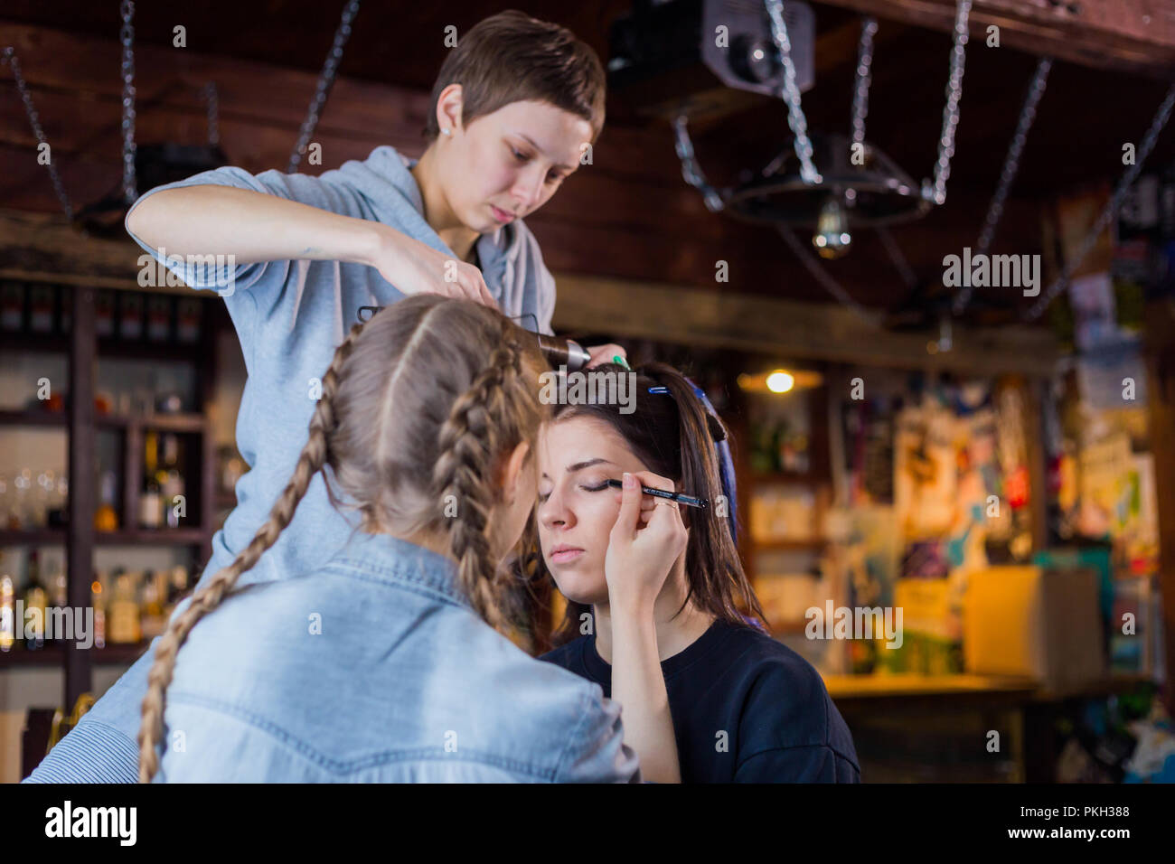 Professional make-up artist and hairdresser working with woman client. Beauty, haircare and make up concept Stock Photo