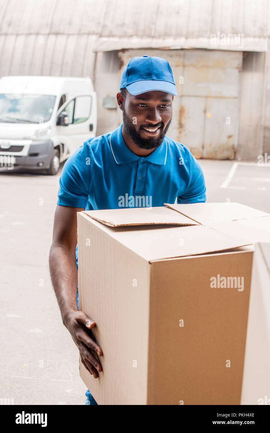 african american delivery man carrying big box Stock Photo